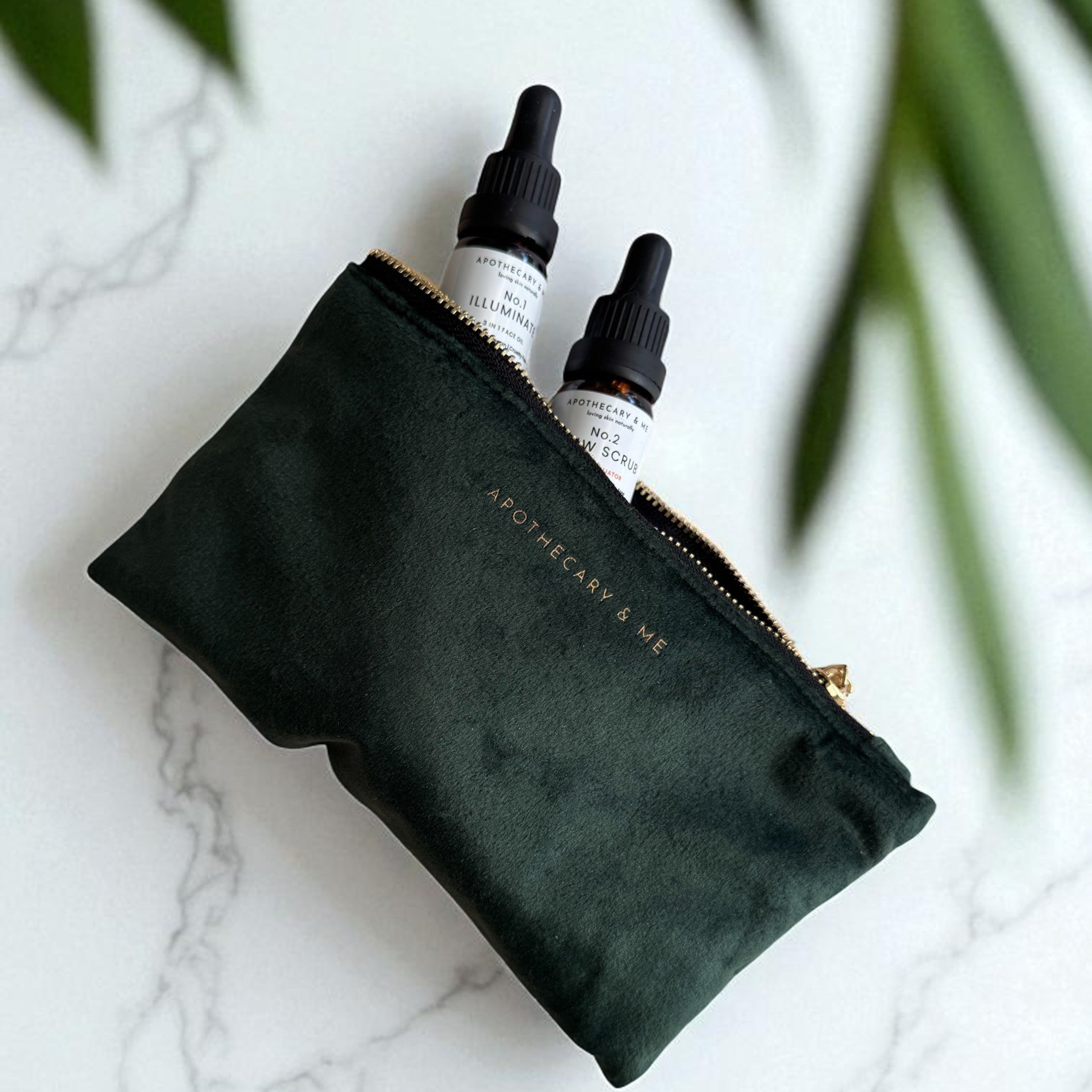 Green pouch with skincare products from Apothecary and me on a marble surface with green leaves in the background