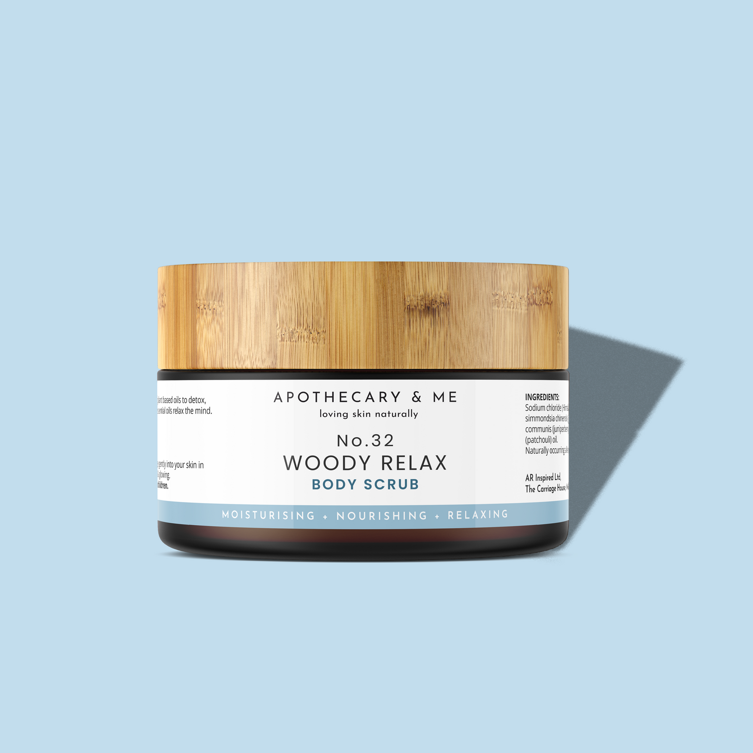 Jar of Apothecary & Me Woody Relax Body Scrub with wooden lid on a light blue background
