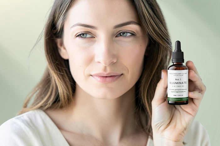 Woman with calm, clear skin holding a bottle of Apothecary & Me No.1 Illuminate Face Oil, a minimal-ingredient fragrance-free face oil as a natural remedy for perioral dermatitis