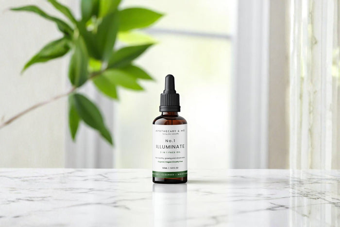  Apothecary & Me No.1 Illuminate Face Oil on a marble surface with a green plant in the background, a natural waterless face oil for eczema-prone skin.