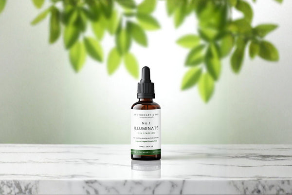 Apothecary & Me No.1 Illuminate Face Oil on a marble surface with soft green leaves in the background, a gentle minimal-ingredient face oil to support skin during topical steroid withdrawal